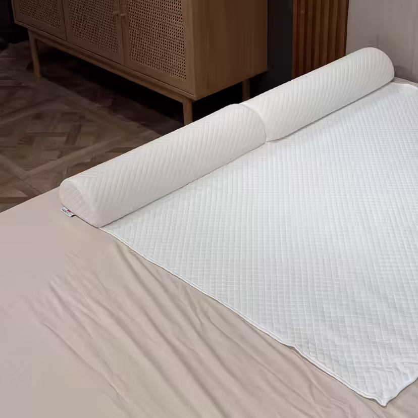 Dygsniuotas putplasčio lovos bortelis po baltu antčiužinio užvalkalu palei lovos kraštą